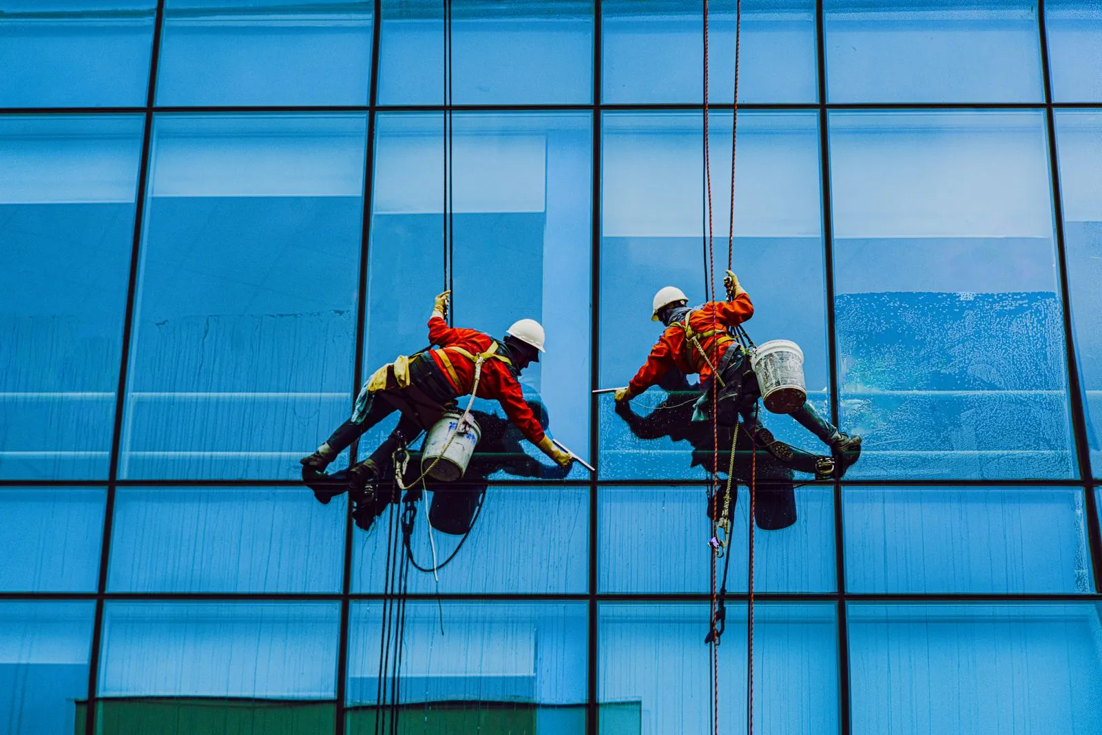 Window cleaners washing the glass facade of a commercial building